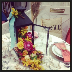 A lantern spilling flowers onto the table lends a subtle beach feeling. 